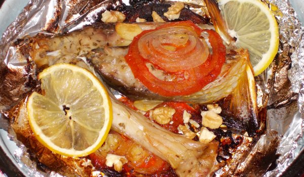Печен шаран във фолио с орехи, лук и домати